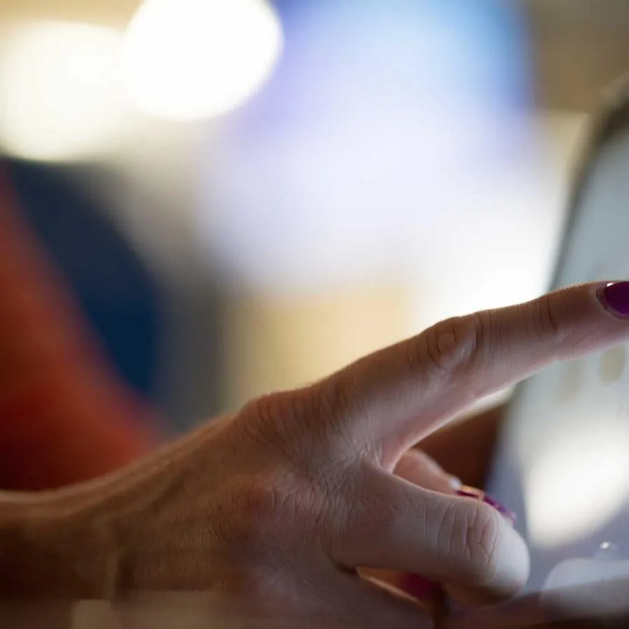 A hand tapping a tablet screen